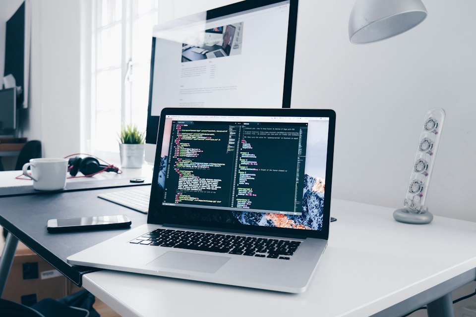 机の上でコードを表示するノートパソコン